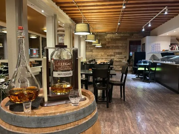 Eine Flasche Whiskey ruht auf einem Holzfass in einem Restaurant.